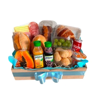 Bandeja de madeira com papel azul, frutas, paes, sucos e frios
